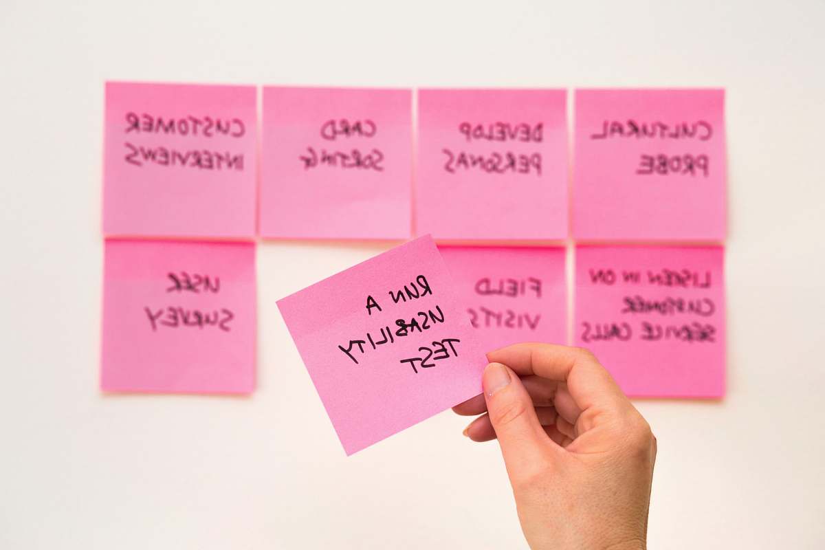 pink person holding pink sticky note paper