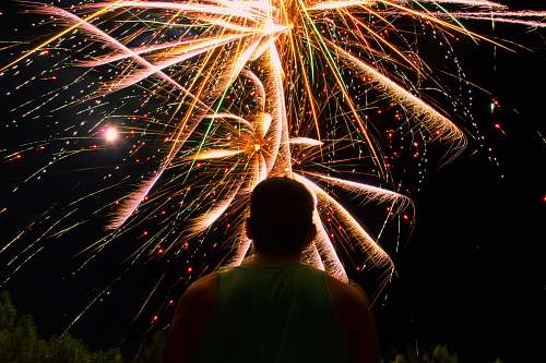 night man watching over firework display during nighttime outdoors