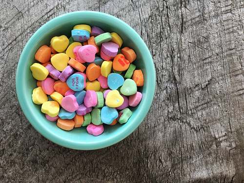 sweets assorted-color heart shape candies on teal bowl bowl