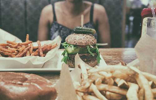 burger burger beside potato fries person