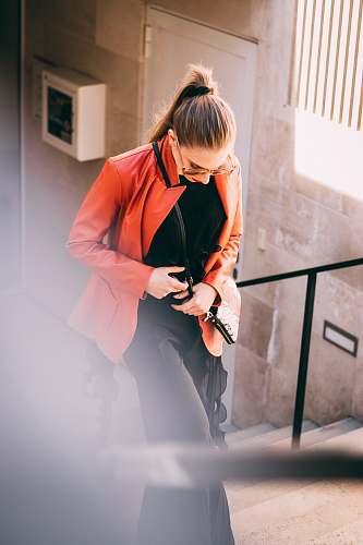 clothing woman wearing orange jacket and black pants with black inner shirts apparel