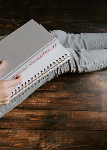 human person holding white notebook text