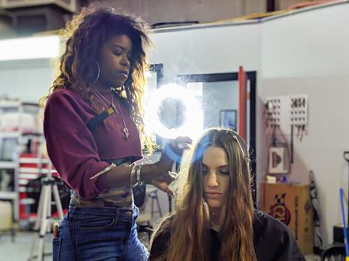 human woman fixing woman's hair apparel