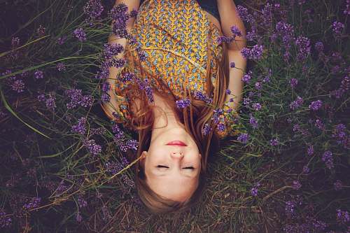 woman woman in yellow and teal top sleeping beside lavenders girl