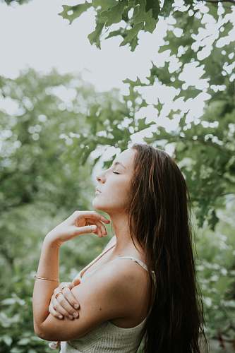 human Woman relaxing with eyes closing while standing among trees person