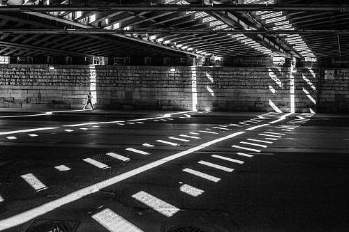 pattern grayscale photography of man walking on road shadow