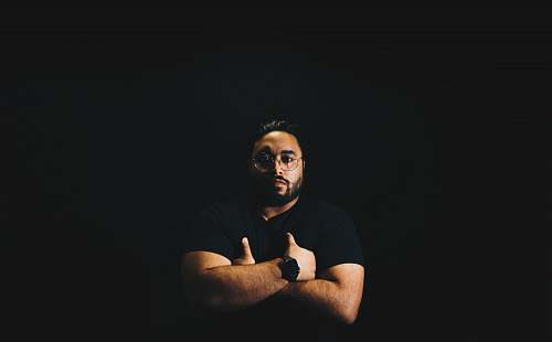 human man wearing black crew-neck shirt with arms crosses man