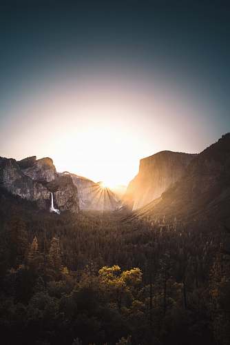 nature gray mountain surrounded with trees during sunrise sunset