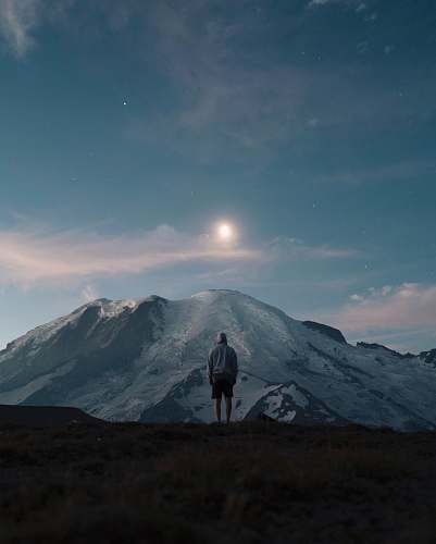 nature man standing on grass field overlooking mountain grey