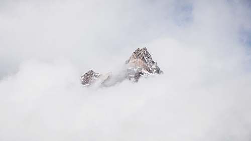grey snow mountain covered with clouds peak