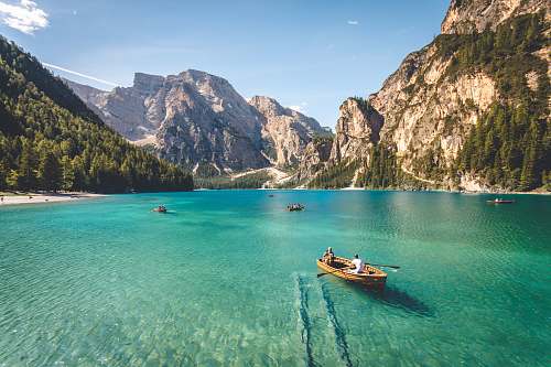 landscape three brown wooden boat on blue lake water taken at daytime italy