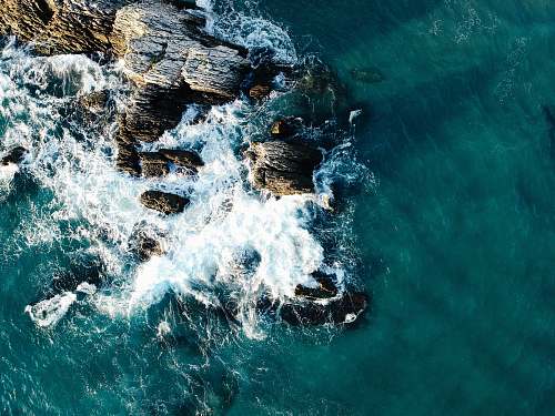 water aerial view photo of rocks near body of water sea