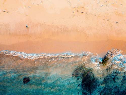 beach drone shot of beach and body of water on brown sand lampuuk beach