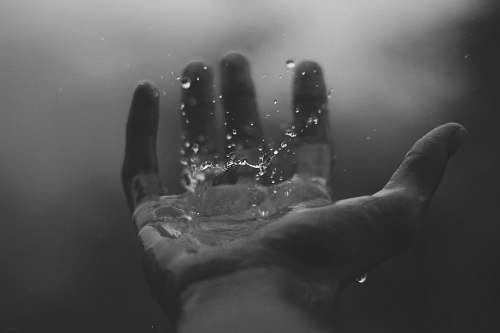 grey time lapse photography of water hitting left palm hand