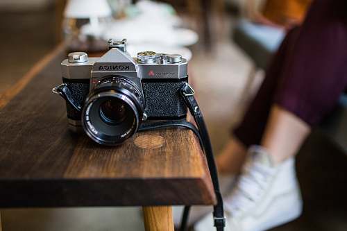electronics selective focus photography of Konica DSLR camera on table human