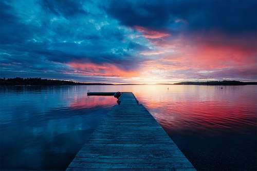 landscape golden hour photography of docking pier on body of water pier