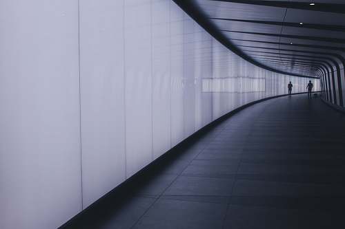  two people walking in hallway 