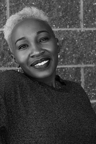 clothing smiling woman by wall black-and-white