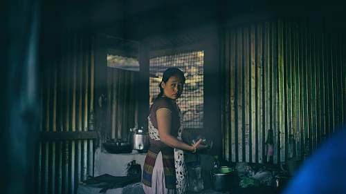 human woman in apron standing near cooking pots person