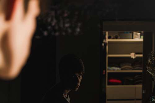 person man facing mirror furniture