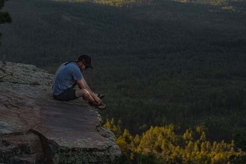 adventure man sitting on ledge leisure activities