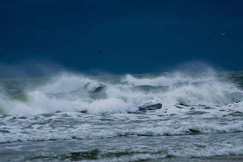 nature photo of sea waves rushing in to the shore outdoors