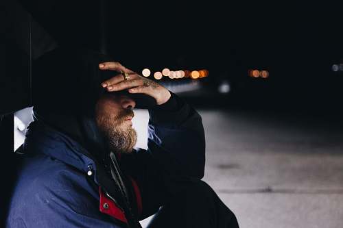 person man sitting at the shed beside the street human