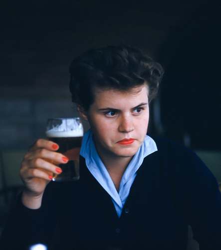 person man sitting while holding glass of beer human