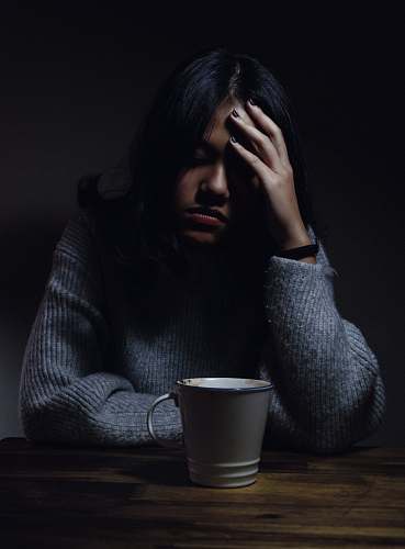 person woman in gray sweater seating on chair cup