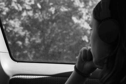people grayscale photo of woman inside car black-and-white