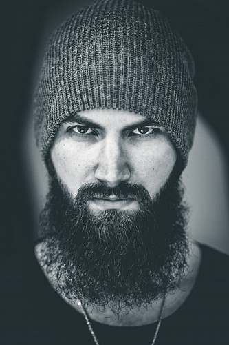 human man in beanie starring face