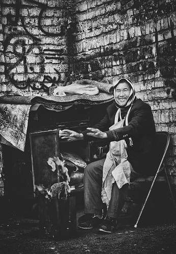 human man sitting on chair black-and-white