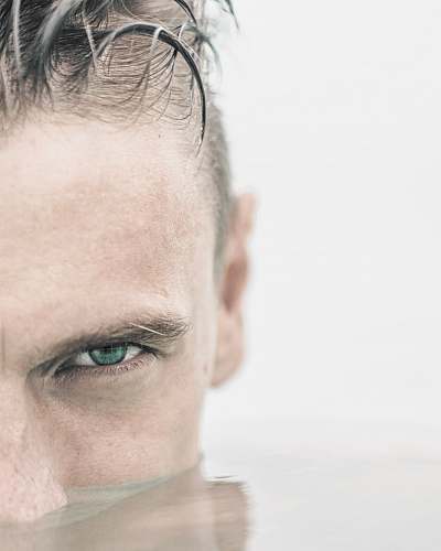 human man's half face in water face