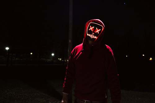 human person wearing black mask standing near post people