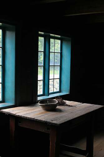 table square brown wooden dining table near blue windowpane indoor