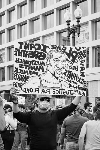 protest grayscale photo of man holding happy birthday signage parade