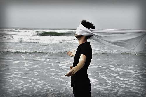 clothing man standing on seashore during daytime sea