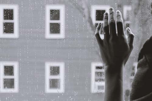 punnamchola grayscale photo of person holding glass window while raining india