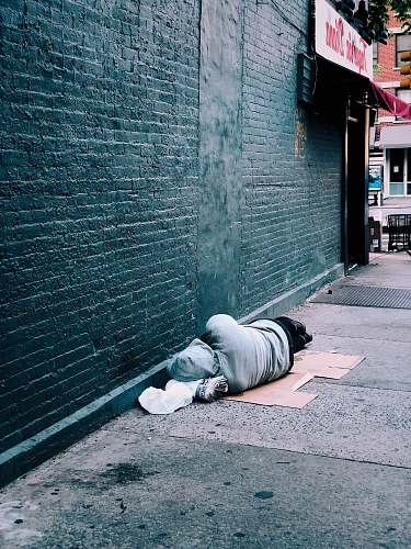homeless man lying on brown cardboard box city