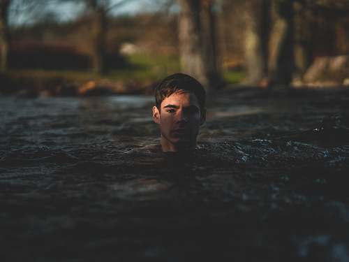 water grayscale photography of man swimming swimming