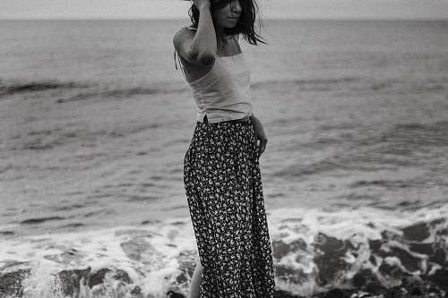 human grayscale photography of woman standing on shore black-and-white