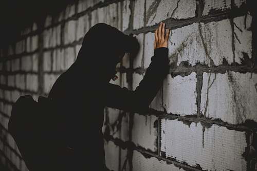 silhouette man leaning on wall brick