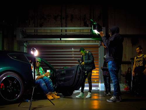 human person sitting in car with opened door near people machine