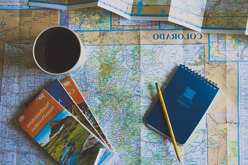 books and pencil on map