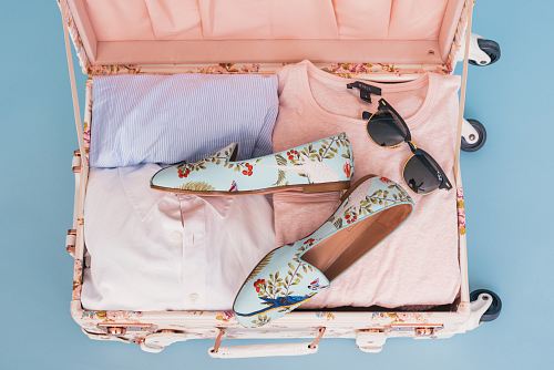 clothing items and pair of shoes in luggage