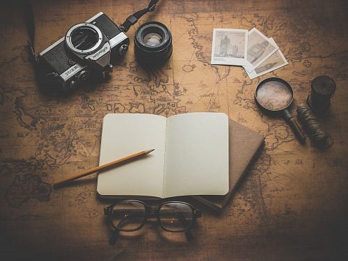 flat ray photography of book, pencil, camera, and with lens