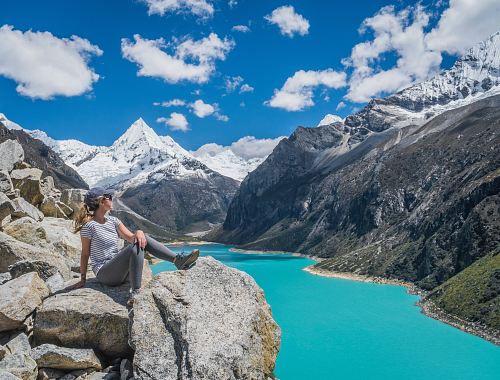 girl sitting on rock near body of water at daytime
