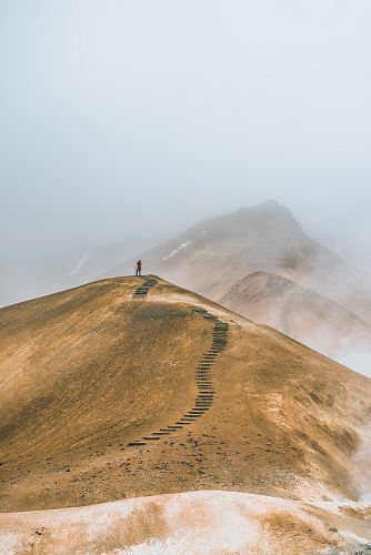 man on top brown hill