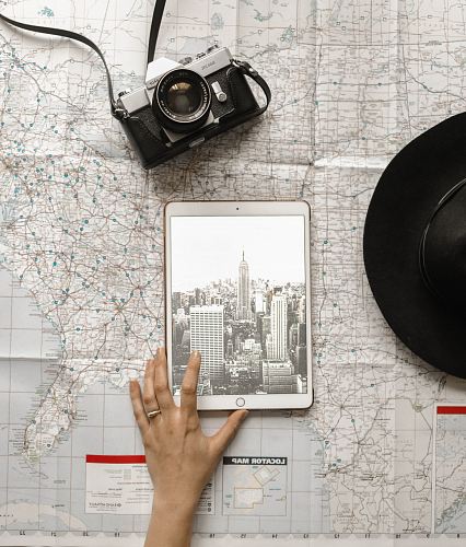 person holding iPad beside SLR camera
