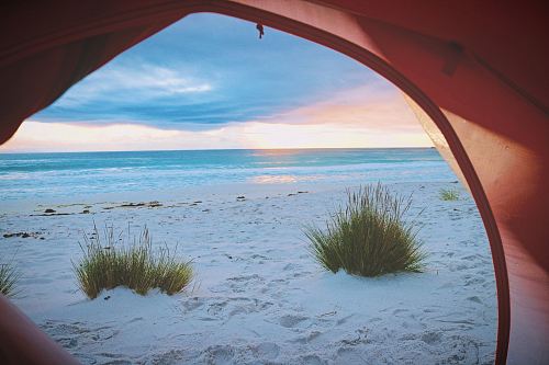 pink tent near white sand near sea